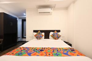 a bedroom with a bed with a colorful blanket on it at FabHotel Excella Vizag in Visakhapatnam