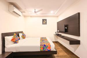 a bedroom with a bed and a tv on a wall at FabHotel Excella Vizag in Visakhapatnam +23 photos