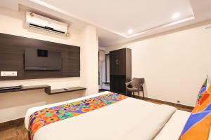 a bedroom with a bed and a flat screen tv at FabHotel Excella Vizag in Visakhapatnam