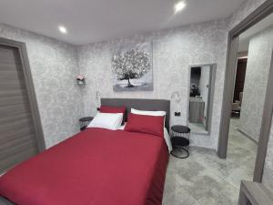 a bedroom with a red bed and a bathroom at B&B Monviso in Casavecchie