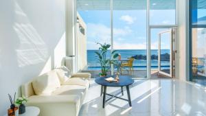 a living room with a white couch and a table at Yeongdeok The Best Pool Villa in Yŏngdŏk