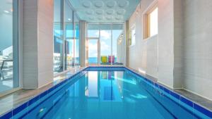 a swimming pool in a building with a view of the ocean at Yeongdeok The Best Pool Villa in Yŏngdŏk