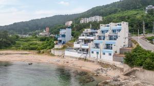 a group of buildings on a beach next to a river at Yeongdeok The Best Pool Villa in Yŏngdŏk