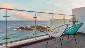 two chairs on a balcony with a view of the ocean at Yeongdeok The Best Pool Villa in Yŏngdŏk