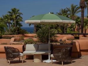 a patio with a table and chairs and an umbrella at Royal Hideaway Sancti Petri in Chiclana de la Frontera