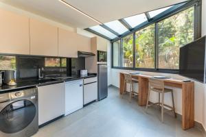 a kitchen with white appliances and a table with chairs at Les Jardins Kaslik in Al Bāţiyah