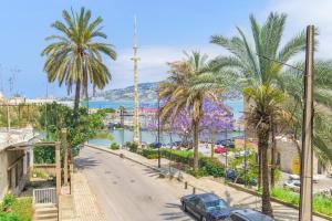 a street with palm trees and a harbor at Les Jardins Kaslik in Al Bāţiyah