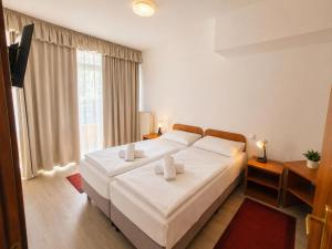 a bedroom with a large white bed with two pillows at PSZ Hotel Beach Földvár in Balatonföldvár