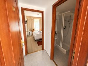 a room with a bathroom with a tub and a bedroom at PSZ Hotel Beach Földvár in Balatonföldvár