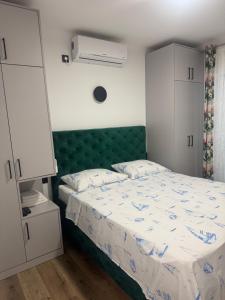 a bedroom with a bed with a green headboard at House 100m from the beach with free parking in Baška Voda