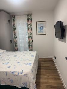 a bedroom with a bed and a flat screen tv at House 100m from the beach with free parking in Baška Voda