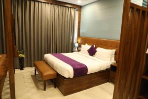 a hotel room with a bed and a window at Hotel Helios in Zirakpur