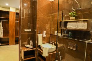 a bathroom with a shower with a toilet and a sink at Hotel Helios in Zirakpur +25 photos