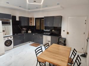a kitchen with a wooden table and chairs at Villa jenni in Temlale