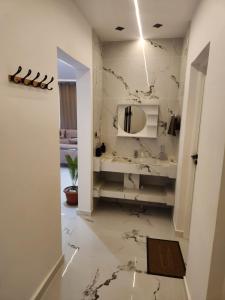 a white bathroom with a marble floor and a mirror at Villa jenni in Temlale +6 photos