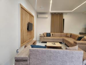 a living room with two couches and a tv at Villa jenni in Temlale