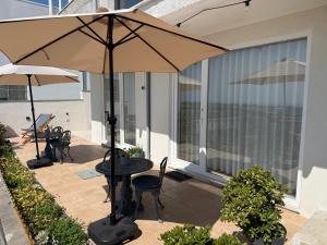 a patio with a table and an umbrella at Alfazema Sunset House in Vila Nova de Gaia