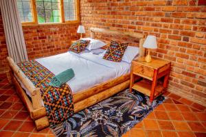 a bedroom with a bed and a brick wall at Tranquil Hillhouse in Nkoanrua