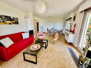 a living room with a red couch and a table at Villa Lake View in Grandvaux