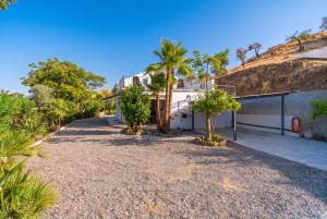 a driveway of a house with palm trees at Cubo's Violeta Rural House in Coín