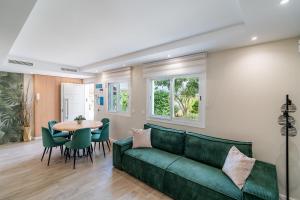 a living room with a green couch and a table at Cubo's Violeta Rural House in Coín
