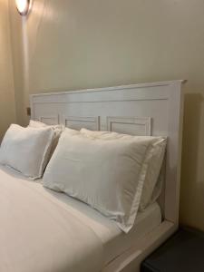 a white bed with white pillows on top of it at Hanik Homes in Kampala