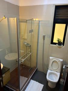 a bathroom with a toilet and a glass shower at Hanik Homes in Kampala +11 photos