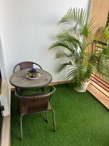 a table and chairs on a balcony with plants at Hanik Homes in Kampala