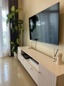a living room with a large television on a wall at Hanik Homes in Kampala