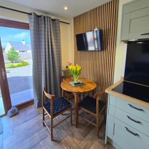 a small kitchen with a table and chairs and a television at Chata in Stornoway