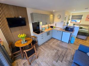 a kitchen and living room with a table and a couch at Chata in Stornoway +5 photos