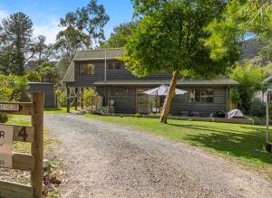 a house with a gravel road in front of it at Cedar Country Retreat in Halls Gap