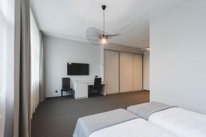 a room with a bed and a desk and a tv at Piktupės slėnis in Piktupėnai