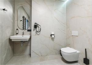 a bathroom with a toilet and a sink and a mirror at Piktupės slėnis in Piktupėnai