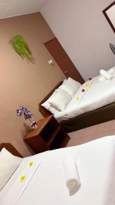 a hotel room with two beds and flowers on the wall at Bunga Raya Resort Parit Buntar in Parit Buntar