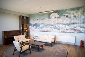 a living room with chairs and a painting on the wall at Piktupės slėnis in Piktupėnai +3 photos