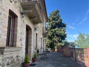 a building with a balcony and a table and chairs at Villa Maria B&B in Marano Principato
