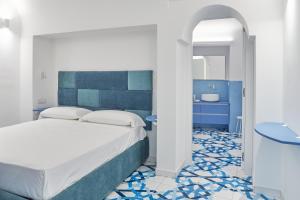 a bedroom with a bed and a bathroom with a sink at Maison Blu Royal in Amalfi