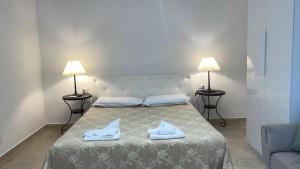 a bedroom with a bed with two lamps and a couch at casa di malika in Borgo Venusio
