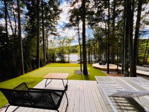 a picnic table and chairs on a wooden deck with a lake at The Lake Villa in Ingramport