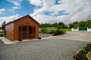 a small wooden shed with glass doors on a driveway at Chata in Stornoway