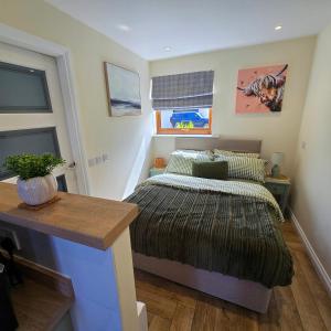 a bedroom with a bed and a table in it at Chata in Stornoway