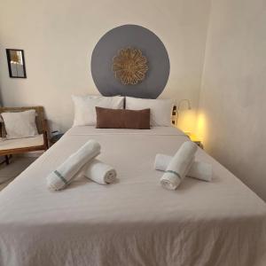 a white bed with three pillows on it at כרמונ'ס פטיו - Carmona's Patio in Eilat