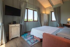 a bedroom with a bed and a flat screen tv at I Quattro Pozzi in La Morra