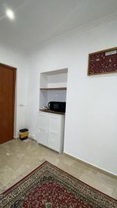 an empty room with a white wall and a kitchen at casa di malika in Borgo Venusio +3 photos