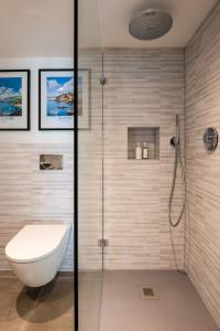 a bathroom with a toilet and a glass shower at The Store in Salcombe +26 photos