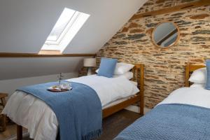 a attic bedroom with two beds and a mirror at The Store in Salcombe