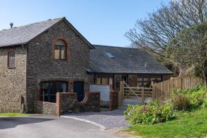 a brick house with a gate and a wooden fence at The Store in Salcombe