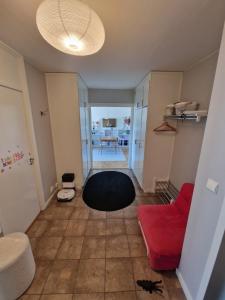 a living room with a red couch and a red chair at Central lägenhet i Visby -4 person inkl parkering in VBY +1 photo