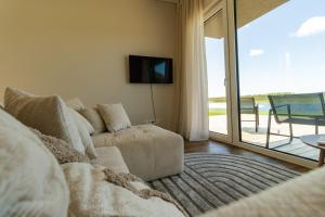 a living room with a couch and a sliding glass door at 313 apartments in Užpelkiai